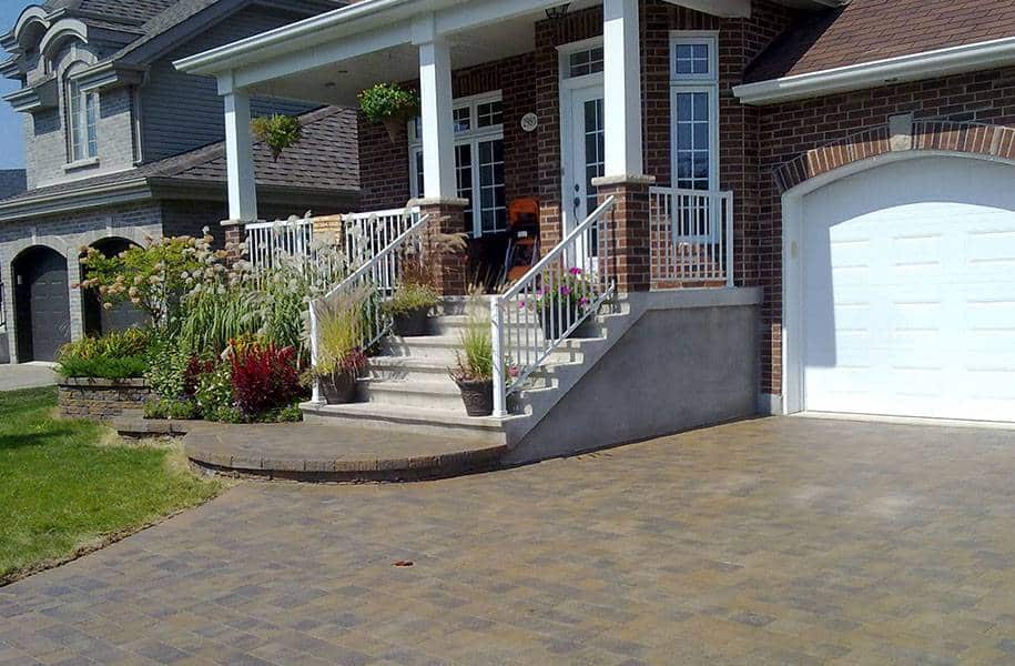 Laying interlocking paving stones in front of a house in Montreal